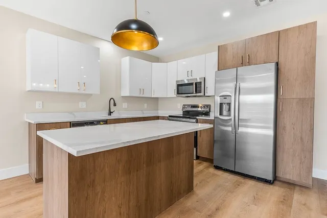a kitchen with stainless steel appliances a refrigerator sink and microwave