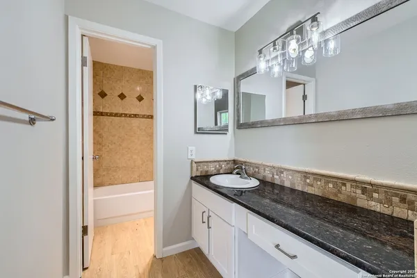 a bathroom with a granite countertop sink and a mirror