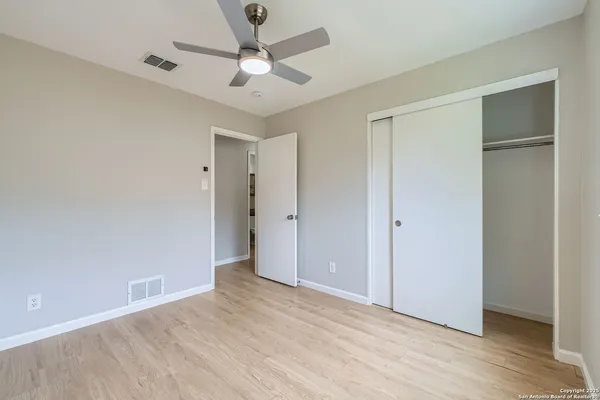 a view of an empty room with wooden floor