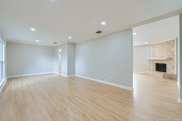 an empty room with wooden floor and fireplace