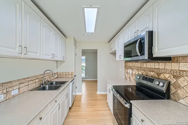 a kitchen that has a sink and a stove top oven
