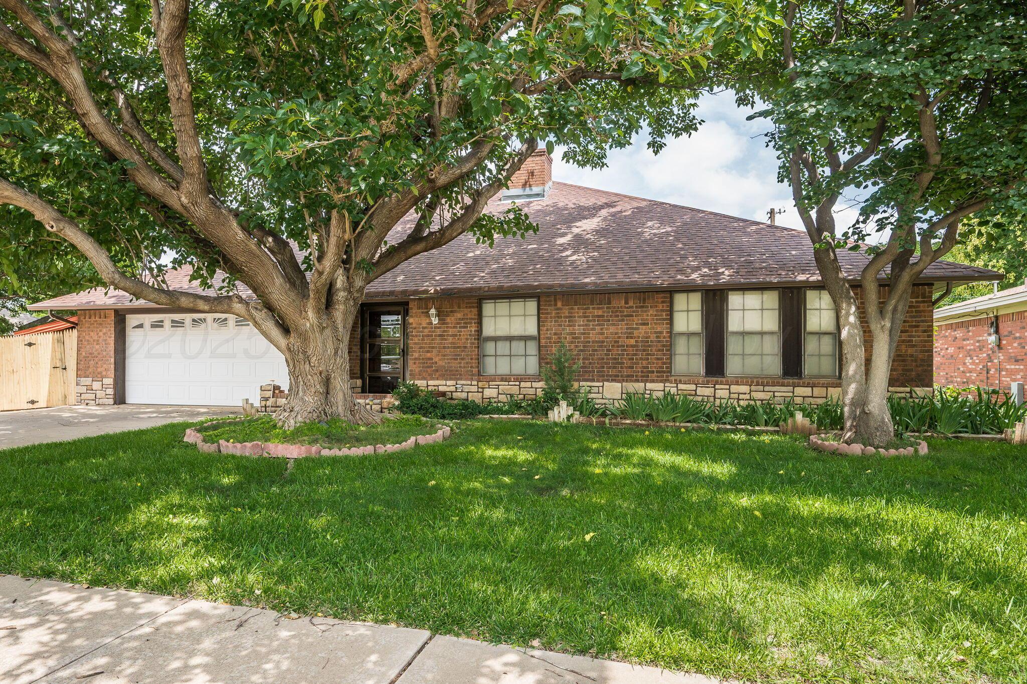 a front view of a house with yard and green space