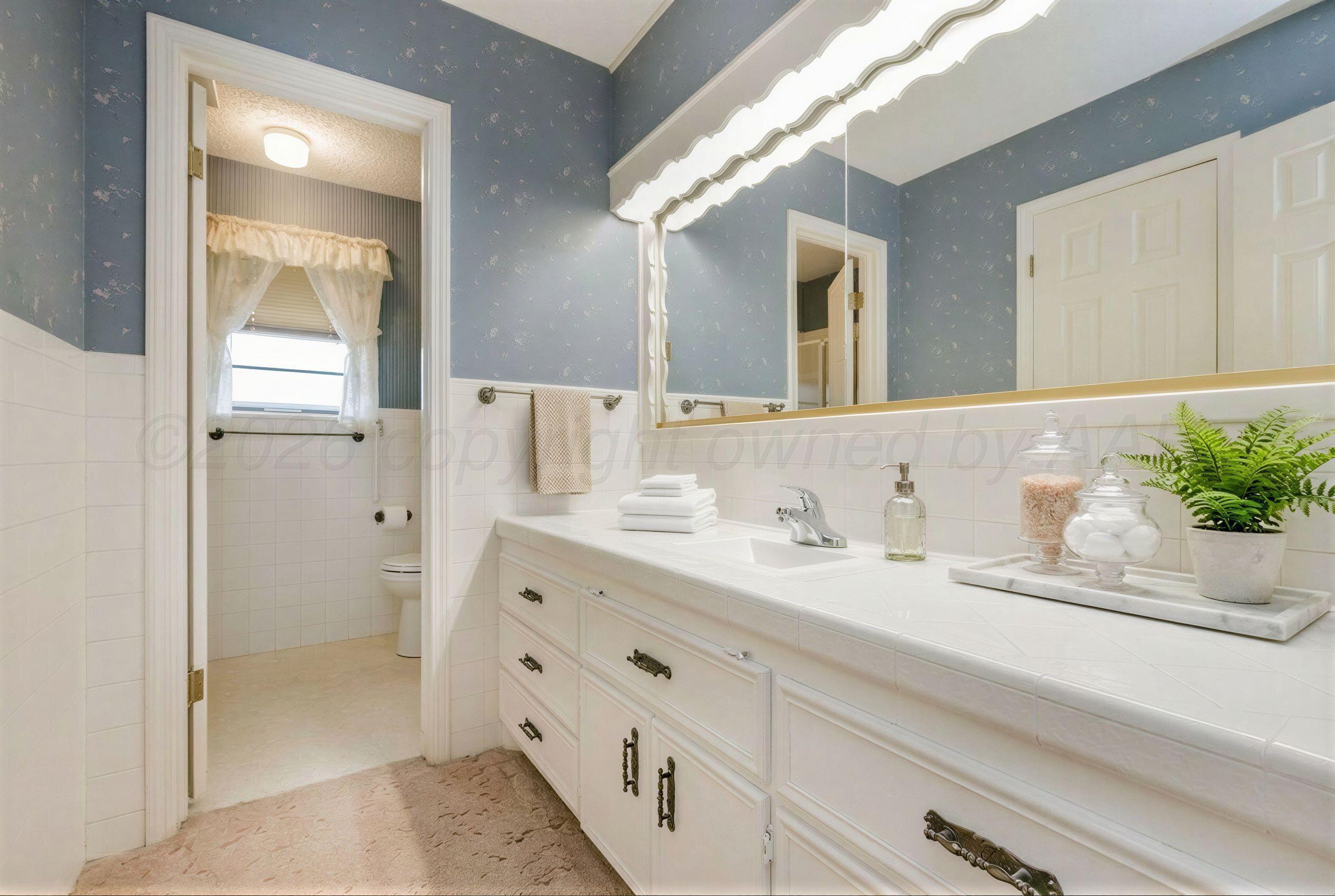 7830 Canode Drive Amarillo, TX 79121 - Photo 23 of 29 a bathroom with a granite countertop sink mirror and double