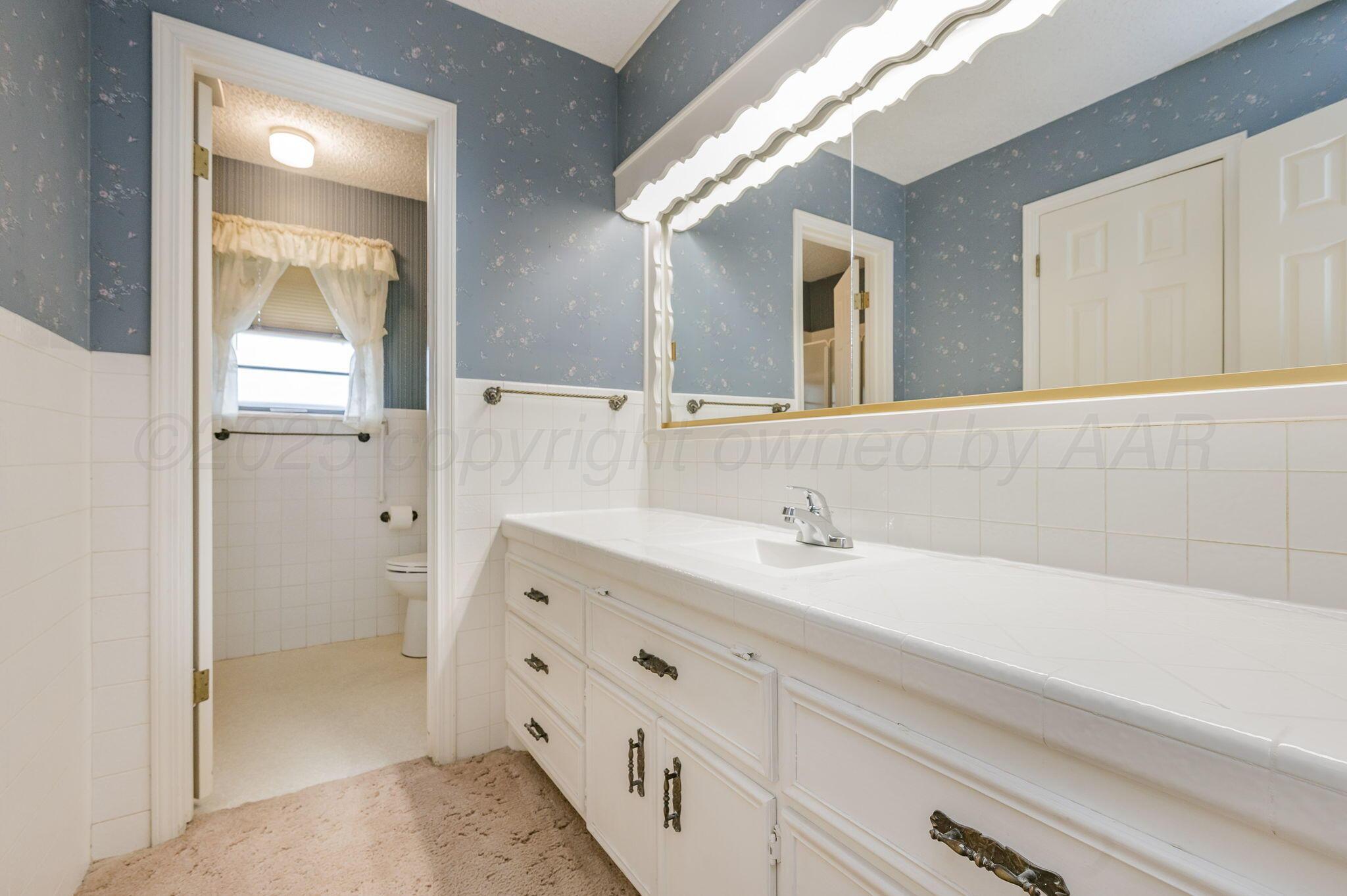 7830 Canode Drive Amarillo, TX 79121 - Photo 24 of 29 a bathroom with a double vanity sink and mirror