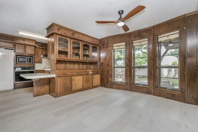 a large kitchen with stainless steel appliances granite countertop a stove and a large window