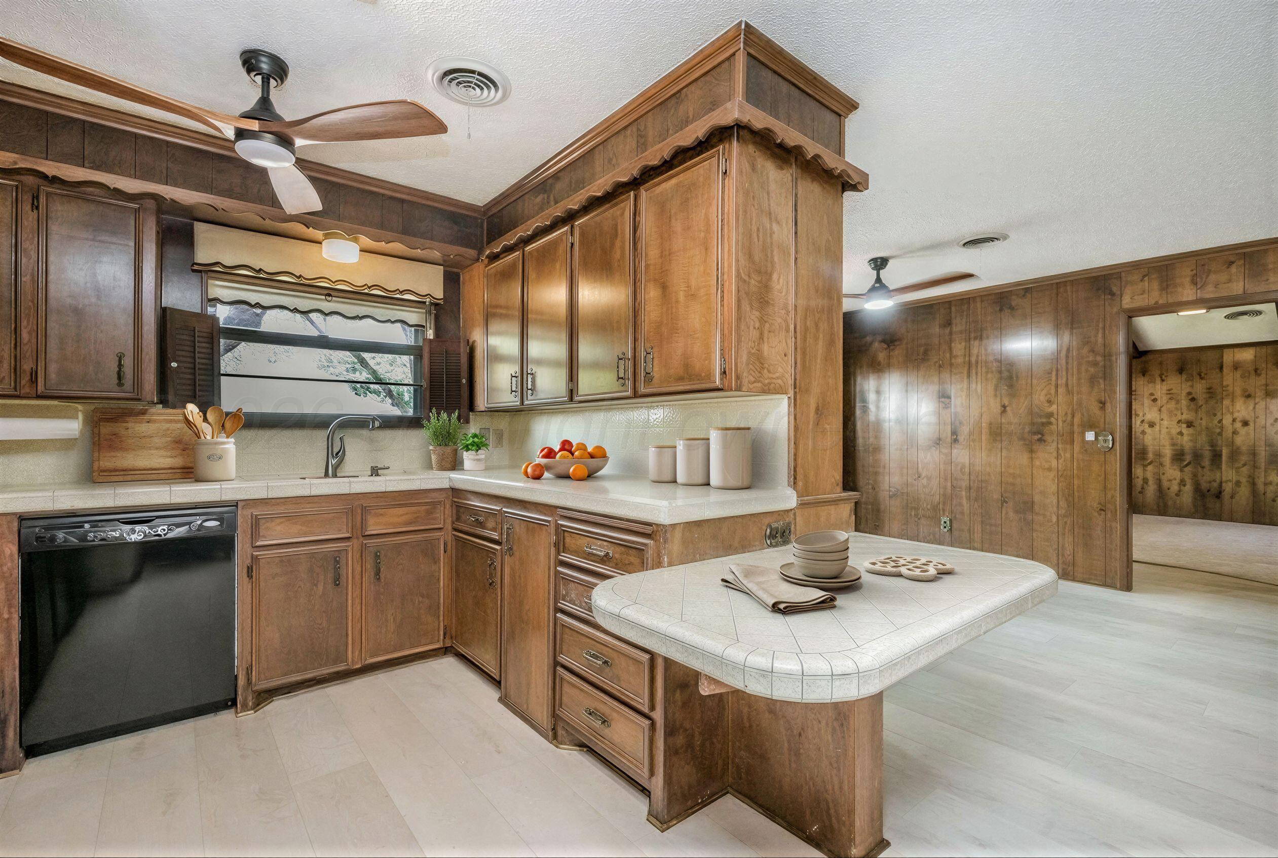 7830 Canode Drive Amarillo, TX 79121 - Photo 10 of 29 a kitchen with a sink a stove and chairs