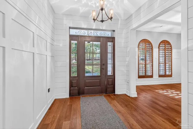 a kitchen with granite countertop a table chairs microwave and refrigerator