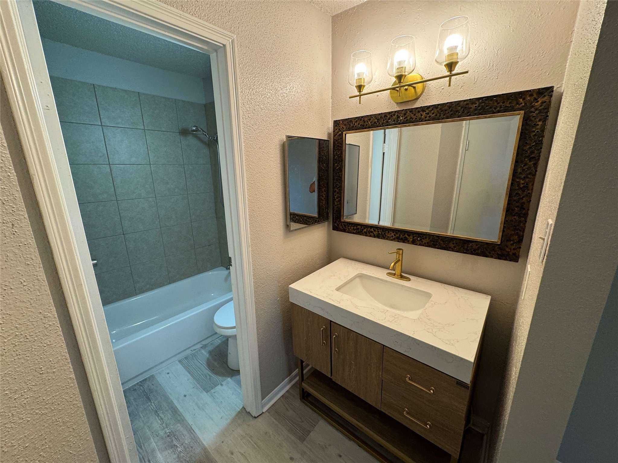 10101 South Gessner Road, Unit 305 Houston, TX 77071 - Photo 11 of 18 a bathroom with a sink a toilet a mirror and shower