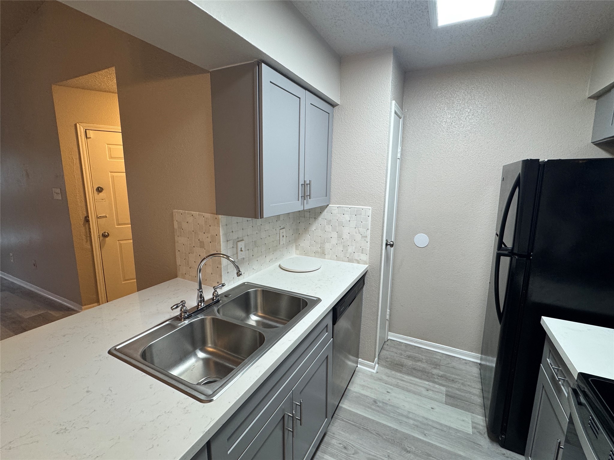 10101 South Gessner Road, Unit 305 Houston, TX 77071 - Photo 4 of 18 a kitchen that has a sink a refrigerator and a stove top oven