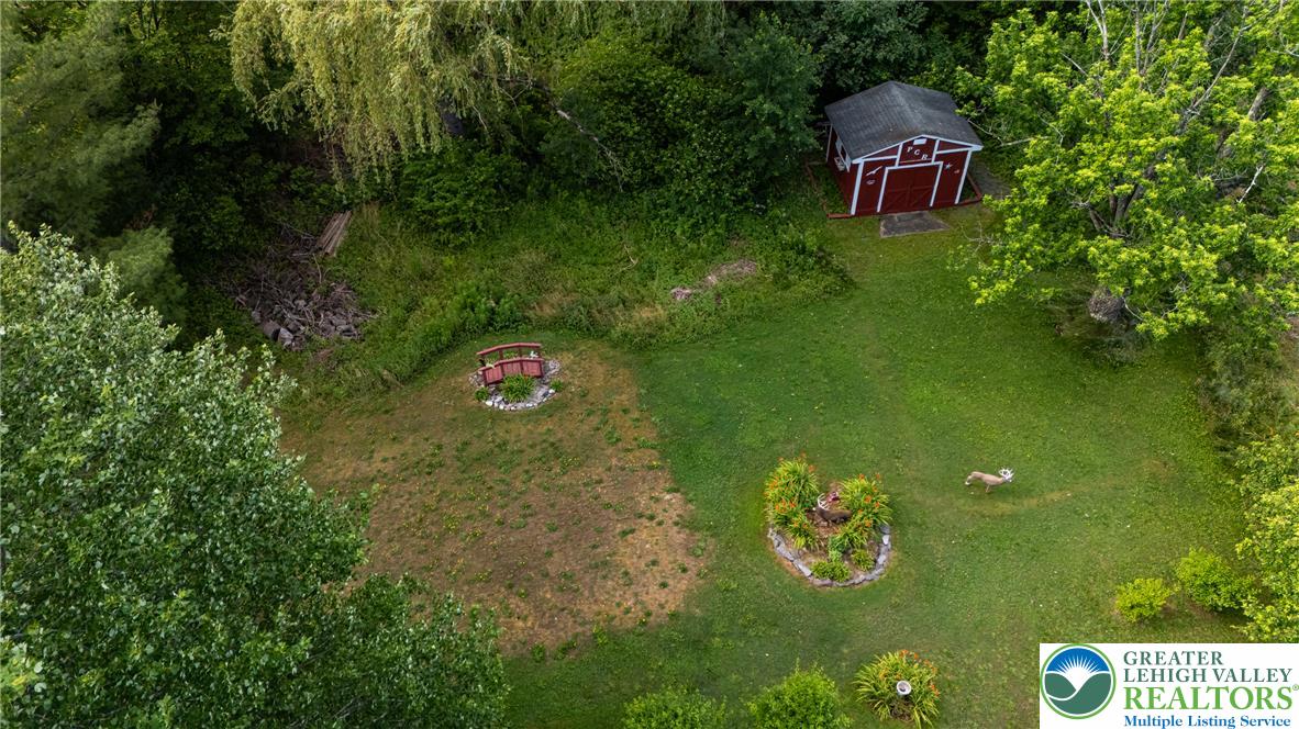 678 Interchange Road Kresgeville, PA 18333 - Photo 4 of 45 A rustic red shed anchors this verdant outdoor space, complete with a charming decorative bridge feature.