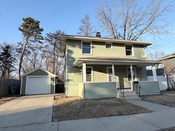a front view of a house with garage and parking