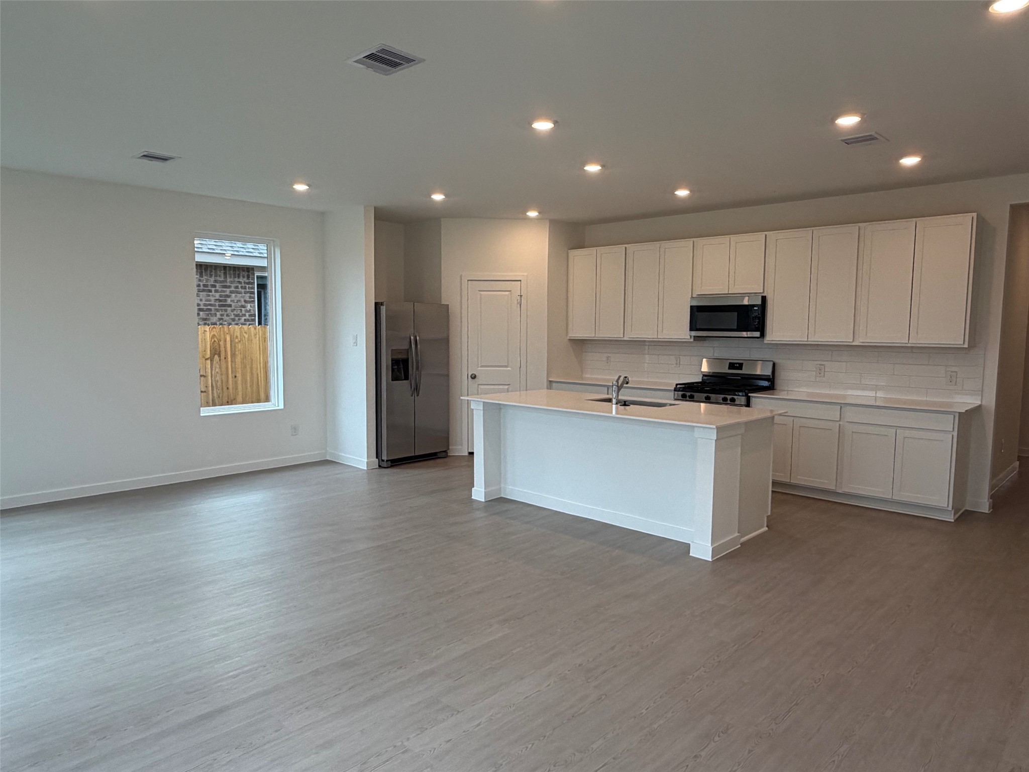 2514 Rose Gold Drive Rosharon, TX 77583 - Photo 9 of 27 a kitchen with stainless steel appliances kitchen island a refrigerator sink and cabinets