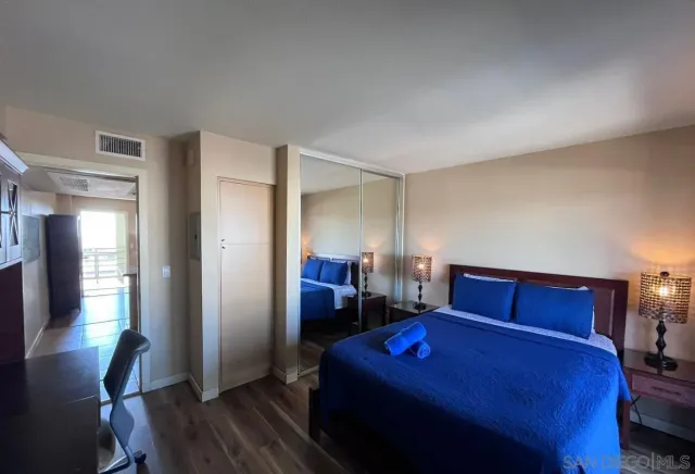 a bedroom with a bed and wooden floor