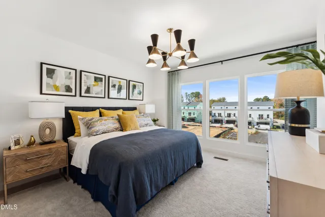 a spacious bedroom with a bed a chandelier and glass door