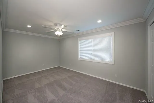 an empty room with a window and a fan
