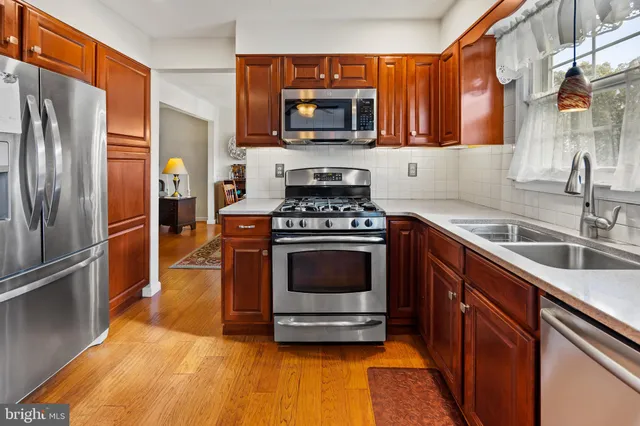 a kitchen with granite countertop a stove top oven and refrigerator