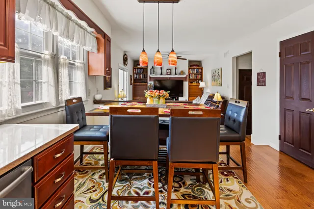 a dining room with furniture a chandelier and wooden floor