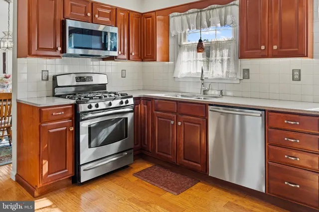a kitchen with stainless steel appliances granite countertop a stove a microwave and a sink