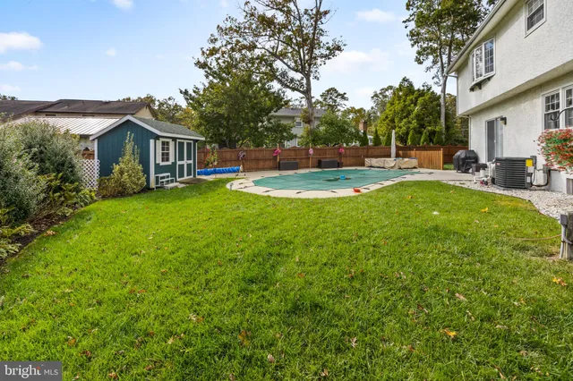 a view of a house with a big yard and large trees