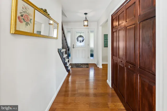 a view of a hallway with wooden floor and staircase