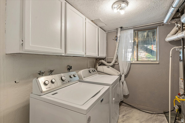 11 South Clark Lane Elk Ridge, UT 84651 - Photo 25 of 46 Laundry room featuring a textured wall, a textured ceiling, washer and clothes dryer, and cabinet space