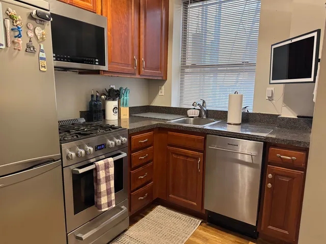 a kitchen with stainless steel appliances granite countertop a sink stove and microwave