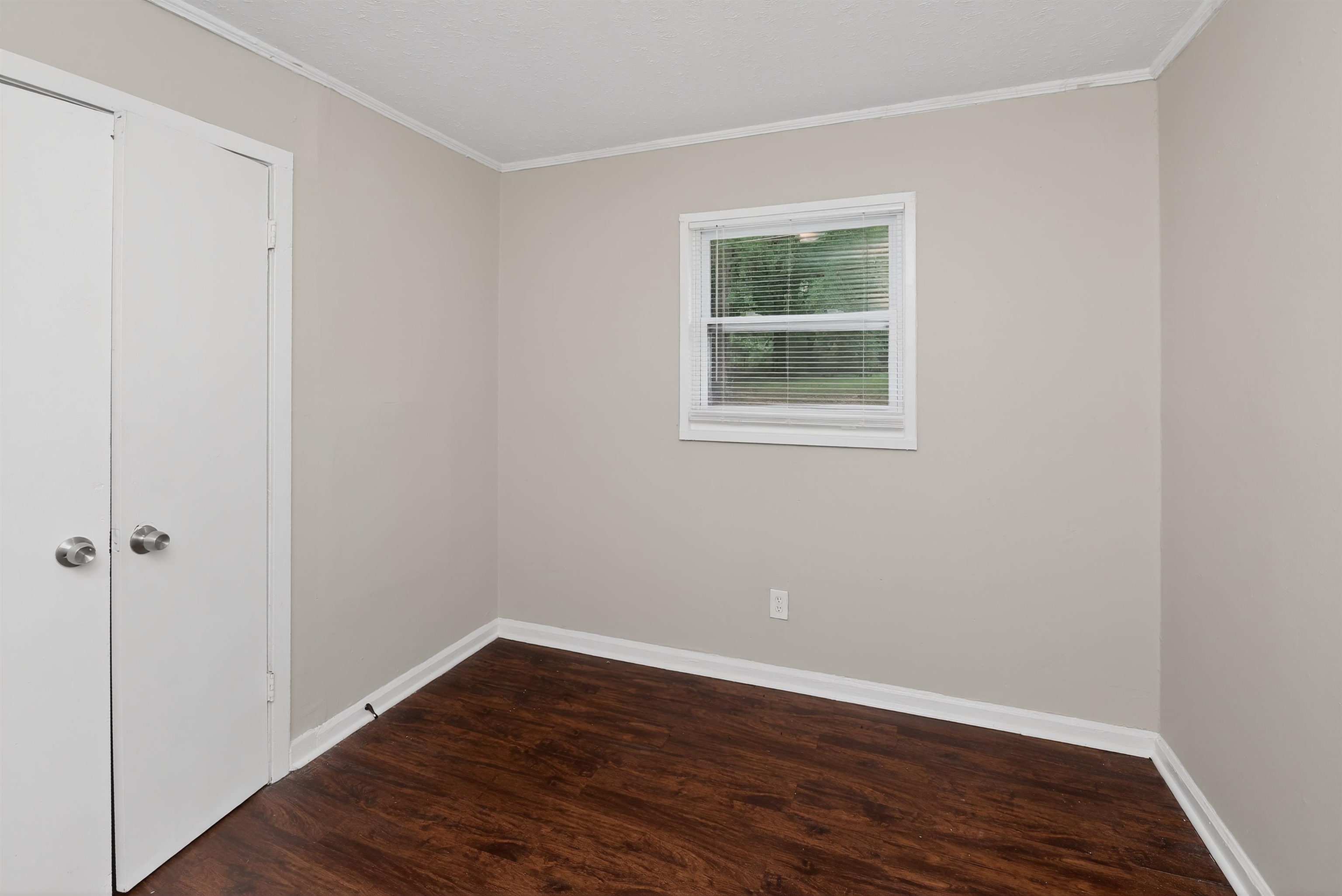 4838 Manson Road Memphis, TN 38109 - Photo 23 of 28 Room featuring wood-finish flooring, neutral wall tones, and white trim