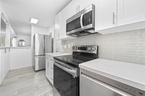 a kitchen with stainless steel appliances a stove microwave and refrigerator