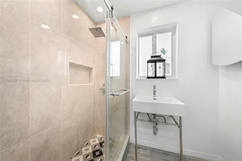 a bathroom with a sink a mirror and a shower