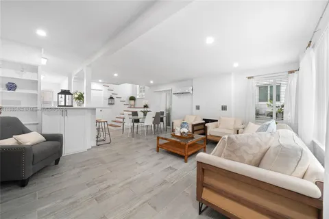 a living room with furniture and view of kitchen