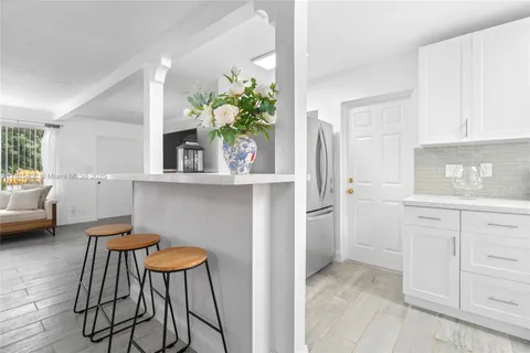 a kitchen with stainless steel appliances kitchen island granite countertop a table and chair in it
