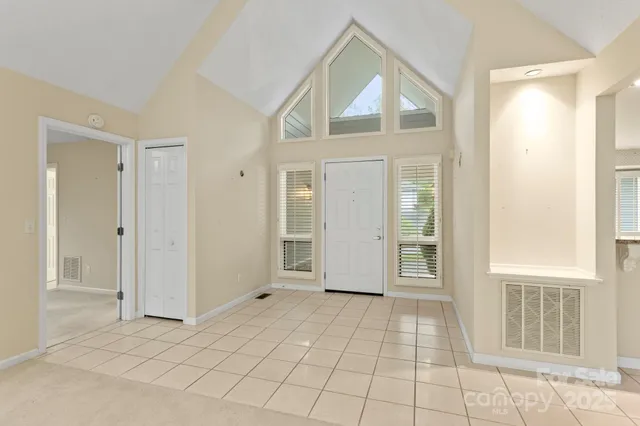 an empty room that has a window and kitchen view
