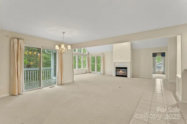 a view of an empty room with a fireplace and a window