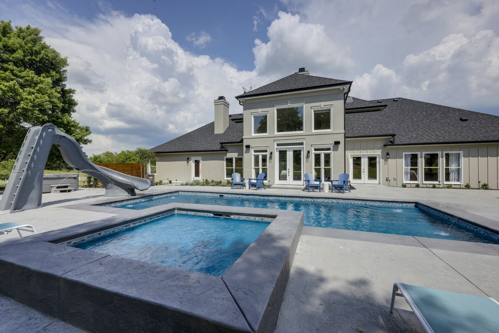 a view of a house with pool and a yard