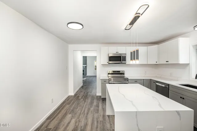 a large white kitchen with a sink and dishwasher