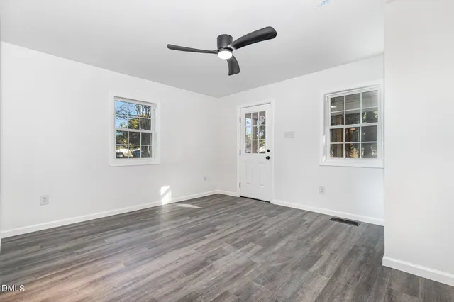 a spacious bedroom with a bed and wooden floor