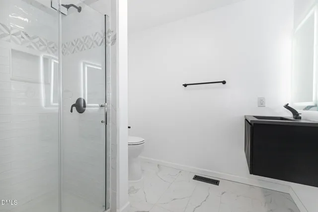 a bathroom with a sink toilet a shower and a window