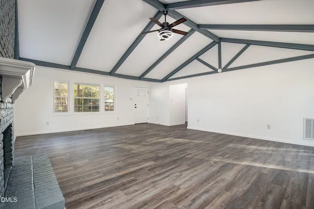 a view of empty room with wooden floor and fireplace