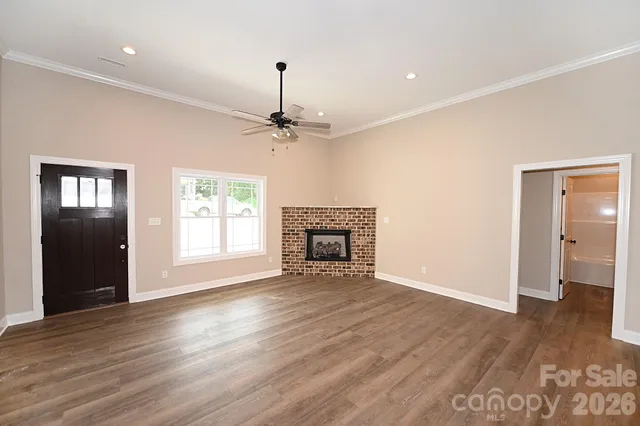an empty room with wooden floor and ceiling fan