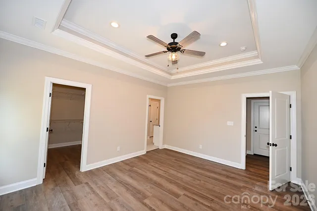 a kitchen with stainless steel appliances granite countertop a sink dishwasher a stove and a refrigerator with wooden floor