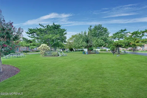 a green field with lots of trees in the background