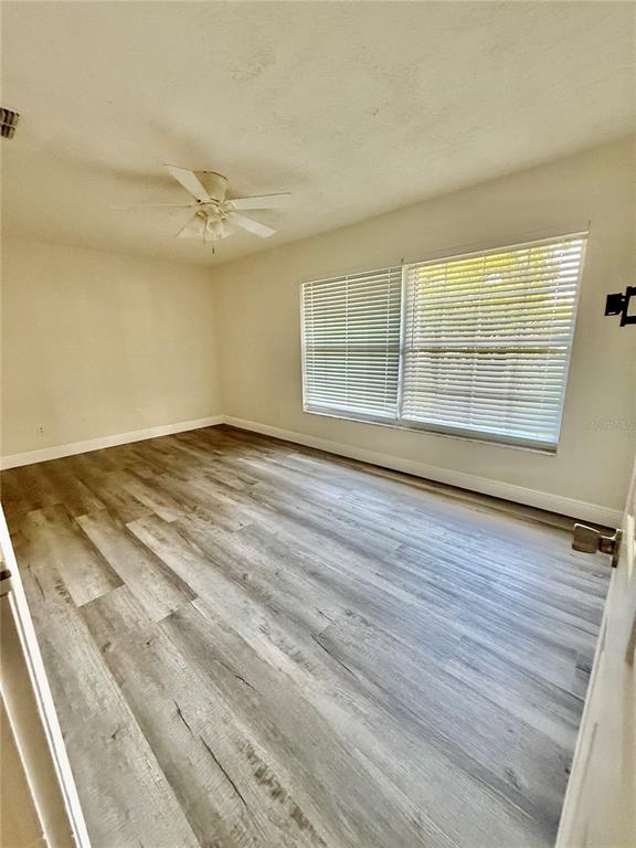 970 Amy Ridge Court Kissimmee, FL 34747 - Photo 12 of 18 wooden floor in an empty room with a window