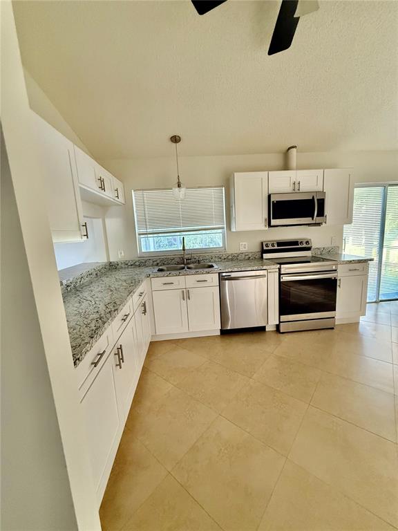 970 Amy Ridge Court Kissimmee, FL 34747 - Photo 14 of 18 a kitchen with stainless steel appliances granite countertop a stove and a sink