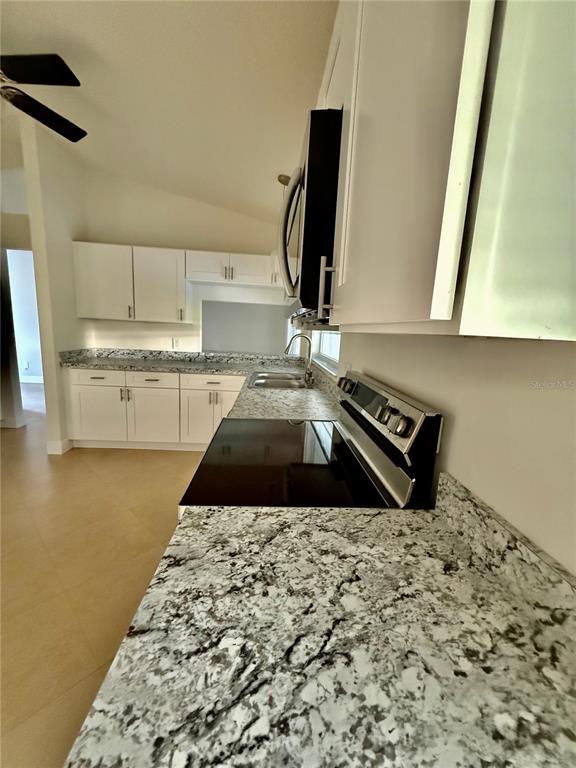 970 Amy Ridge Court Kissimmee, FL 34747 - Photo 9 of 18 a kitchen with a stove and a white cabinet