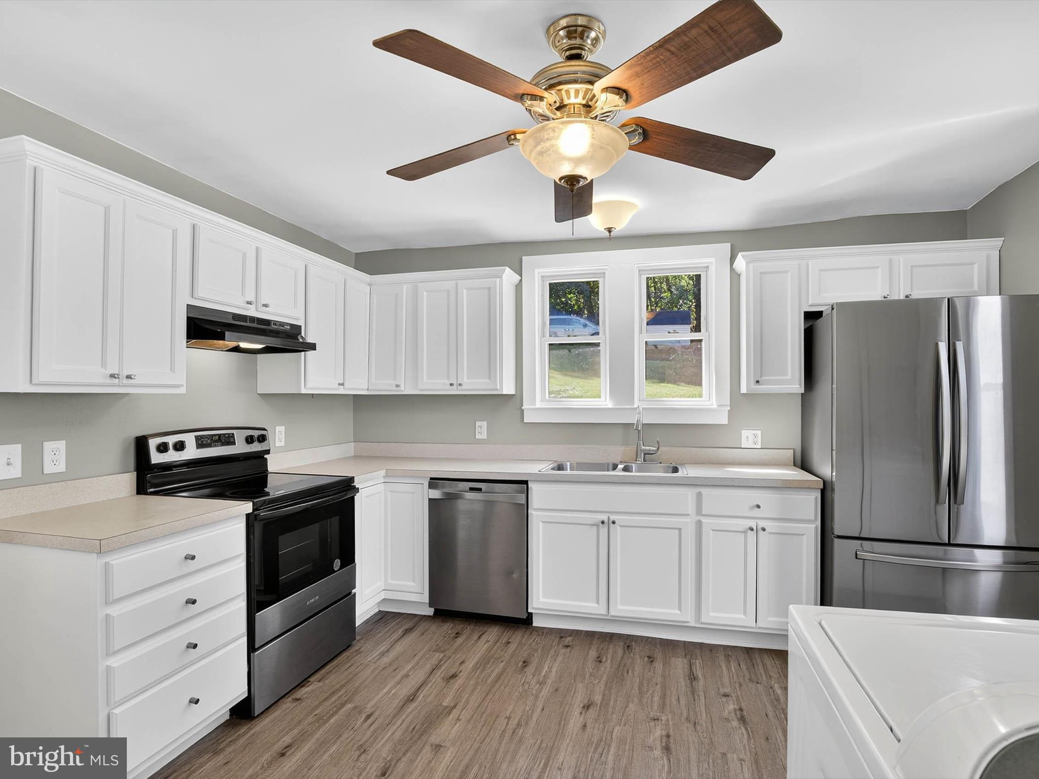5334 Strasburg Road Kinzers, PA 17535 - Photo 8 of 44 a kitchen with stainless steel appliances granite countertop a stove a sink dishwasher a refrigerator white cabinets and wooden floor