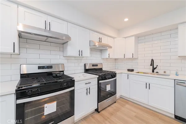 a kitchen with stainless steel appliances granite countertop a stove and a sink