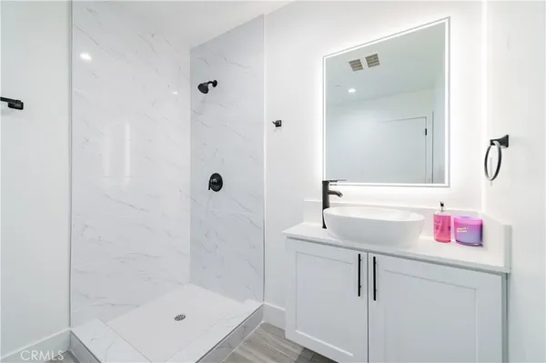 a bathroom with a shower sink vanity and mirror