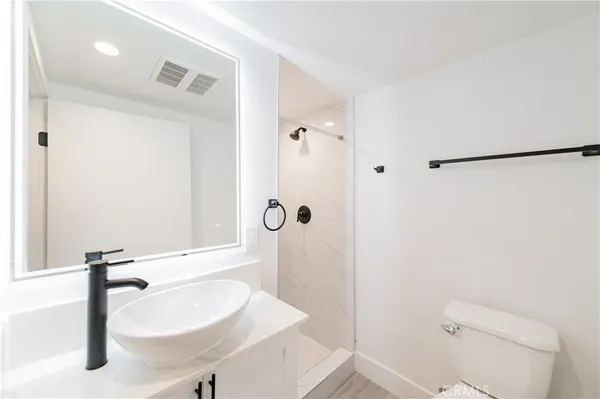 a bathroom with a sink a toilet and shower