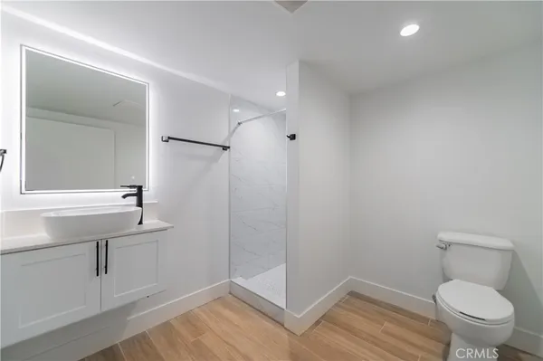 a bathroom with a sink a toilet a mirror and shower