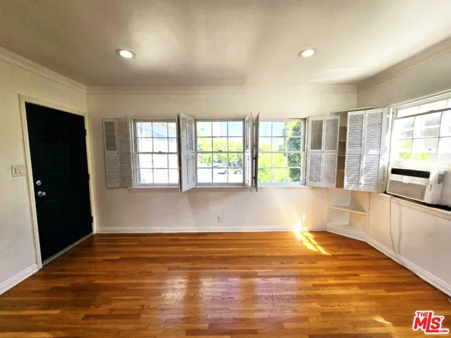 a view of a room with wooden floor and windows